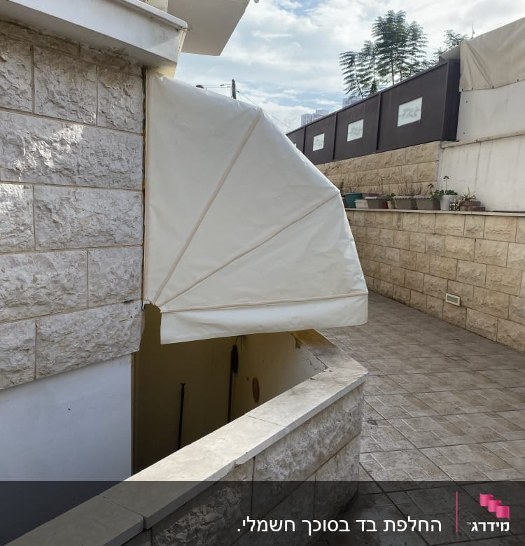 סוכך בד לבן מקופל מעל כניסה